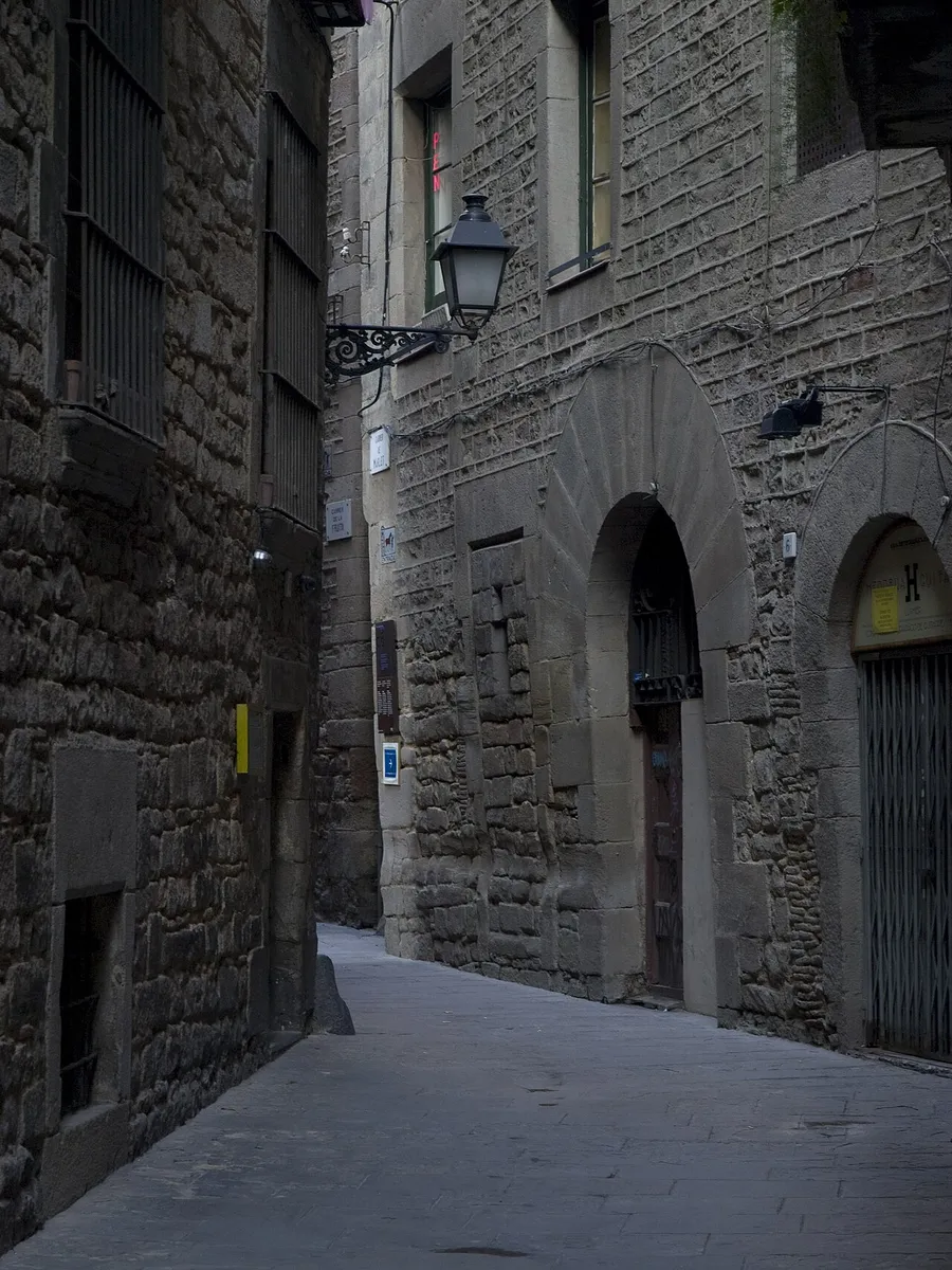 A narrow stone lane in the Call with arched doorways and an iron street lamp