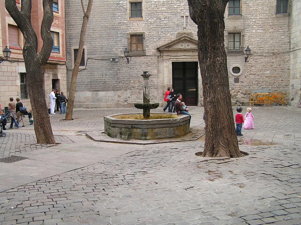 Plaça de Sant Felip Neri with its central fountain, two trees and the church front behind