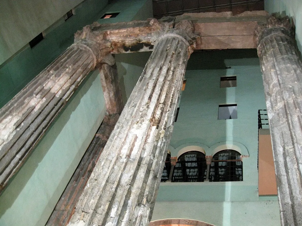 Fluted Roman columns with Corinthian capitals, seen from below inside a courtyard
