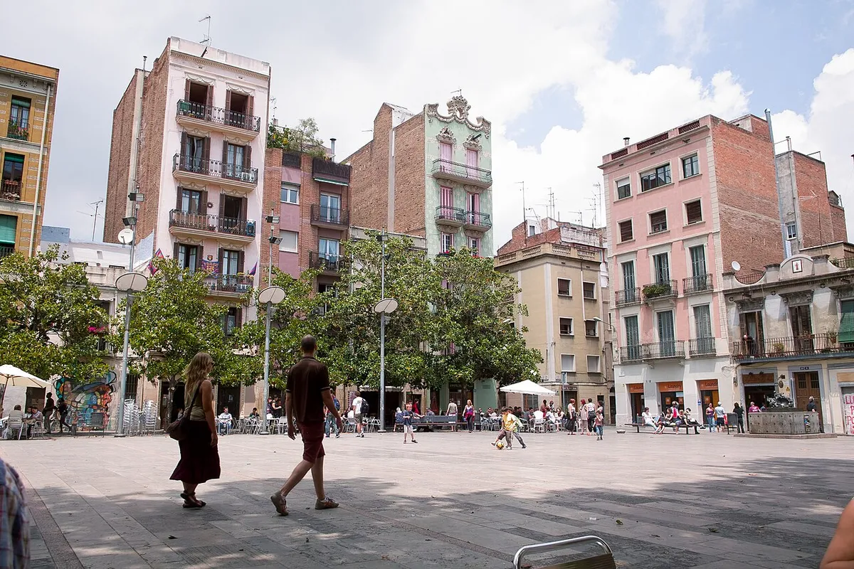 The paved open space of Plaça del Sol, with trees, café terraces and apartment buildings of different heights