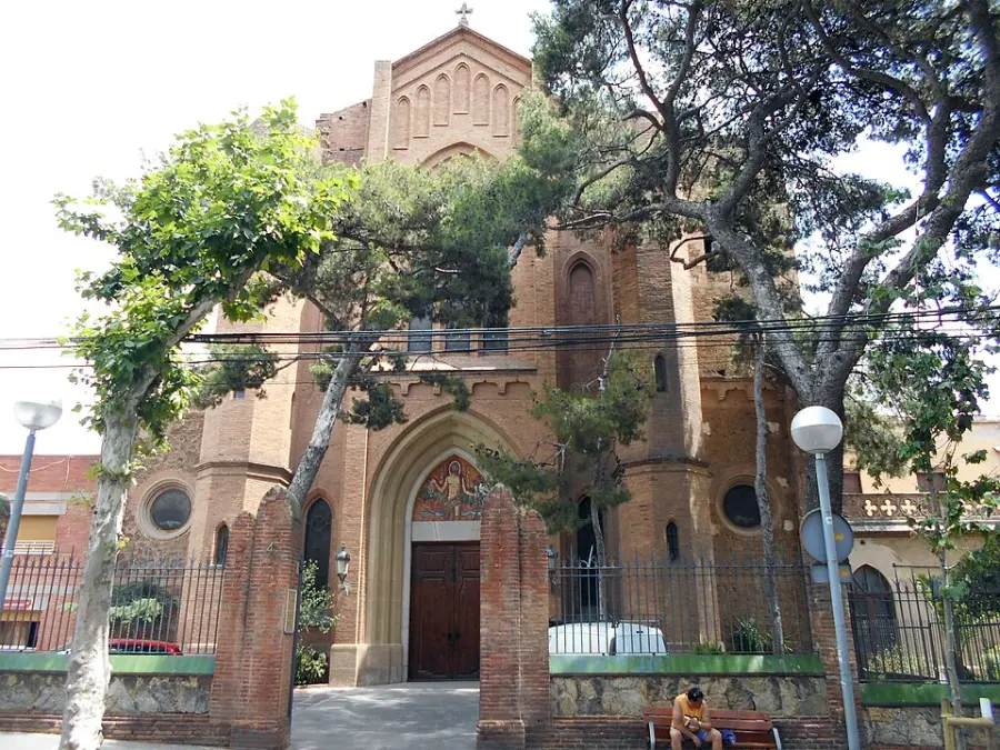 The neo-Gothic front of the church of Sant Joan d'Horta behind trees