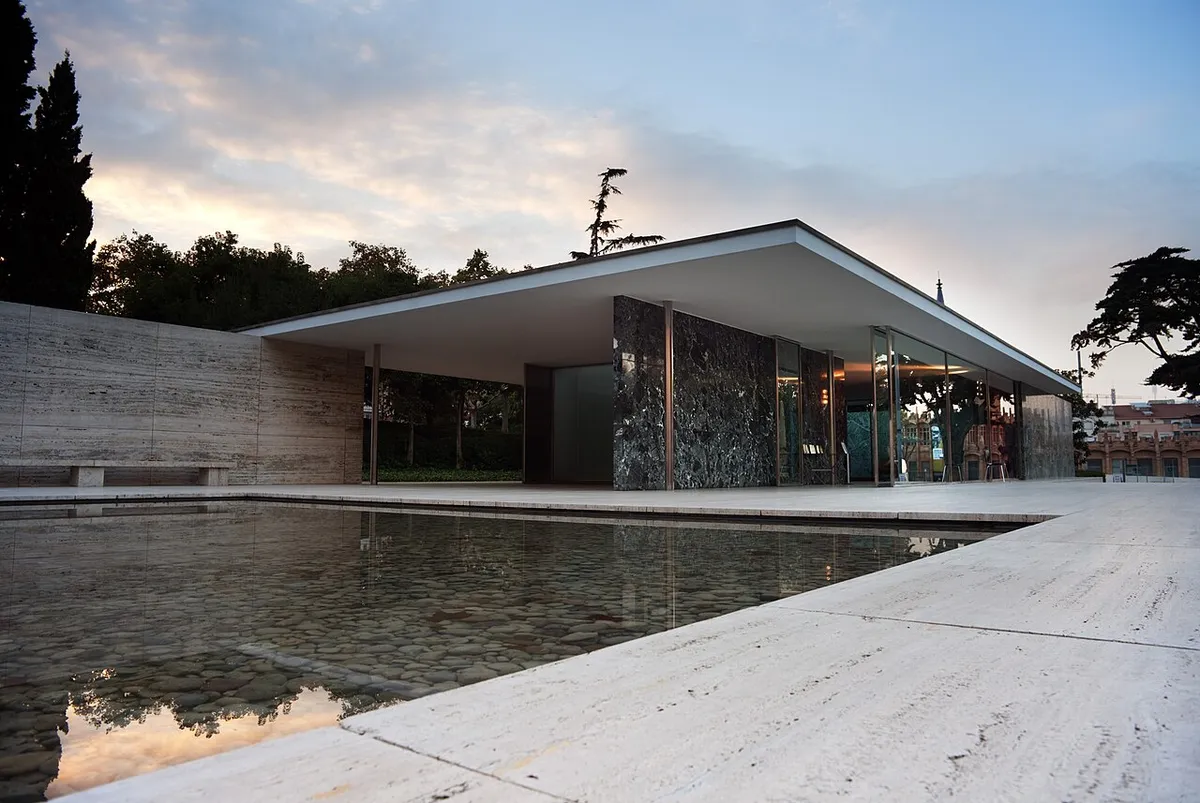 The Barcelona Pavilion: a flat roof over marble and glass walls, beside a shallow pool on a travertine base