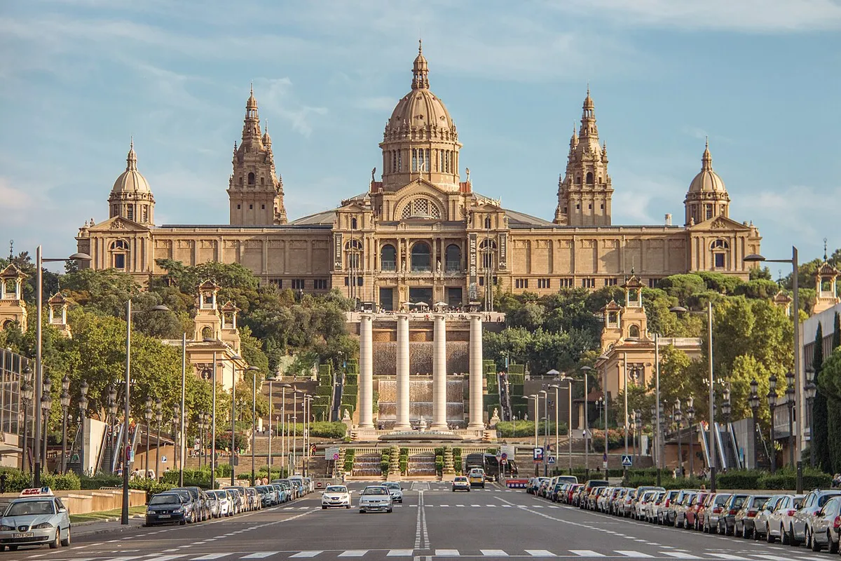 The Palau Nacional on the hilltop, with its central dome and corner towers, above cascades and the four columns