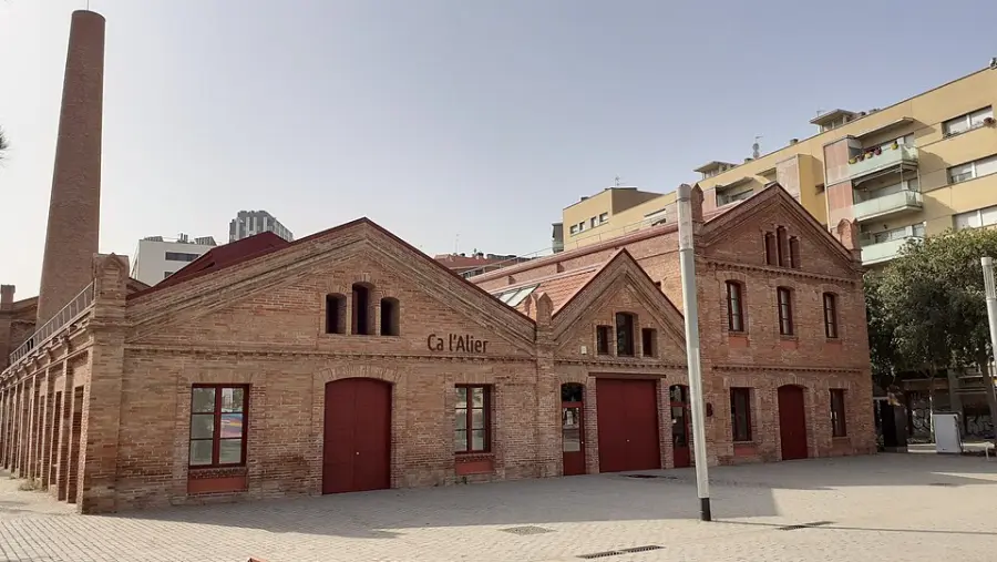 The restored Ca l'Alier factory building with its round brick chimney