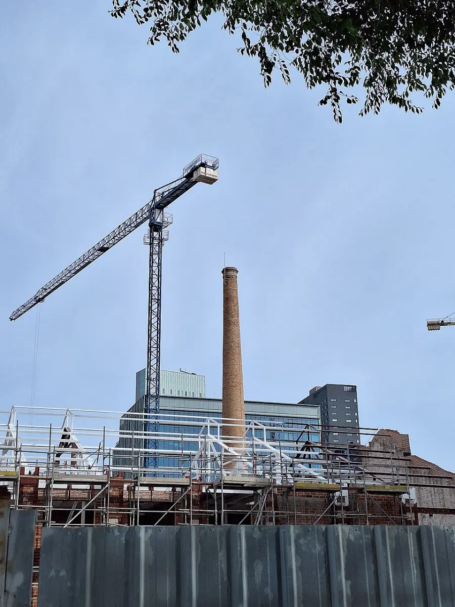 The tall brick chimney of Can Ricart against the sky