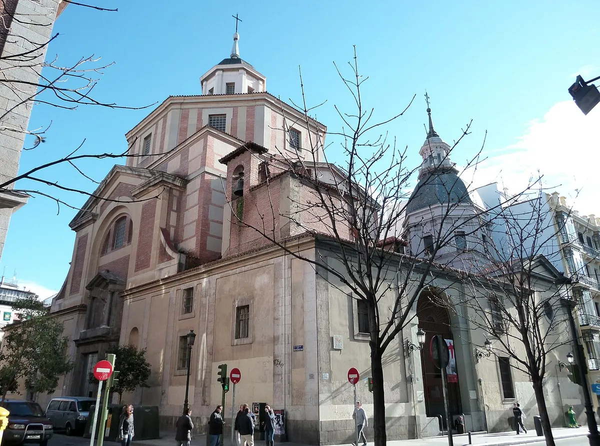 The church of San Sebastián on Calle de Atocha, a pink and cream building with a large central dome and a smaller domed tower, behind bare trees